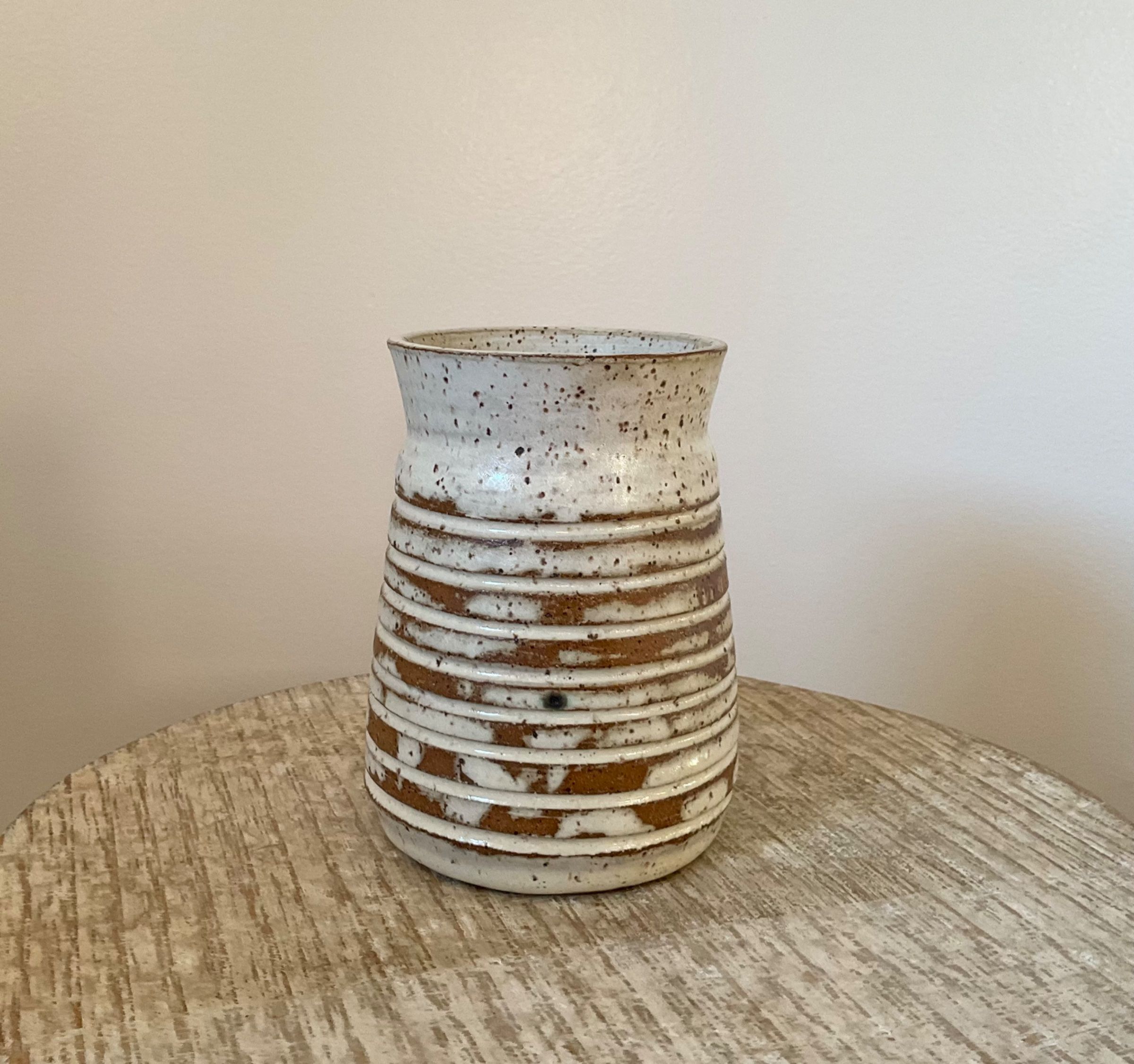Short vase with grooved lines.