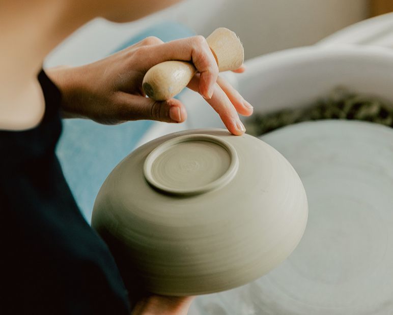 A maker shaping a vessel by hand