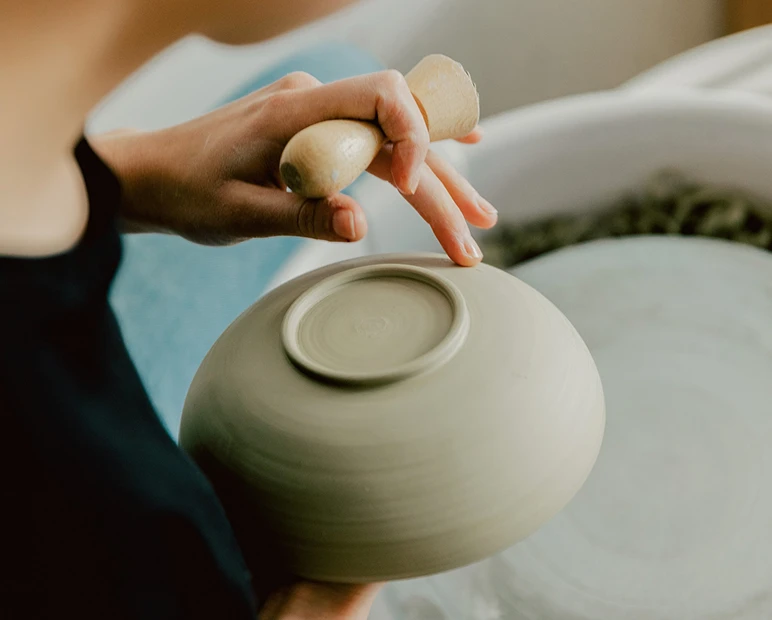 A maker shaping a vessel by hand
